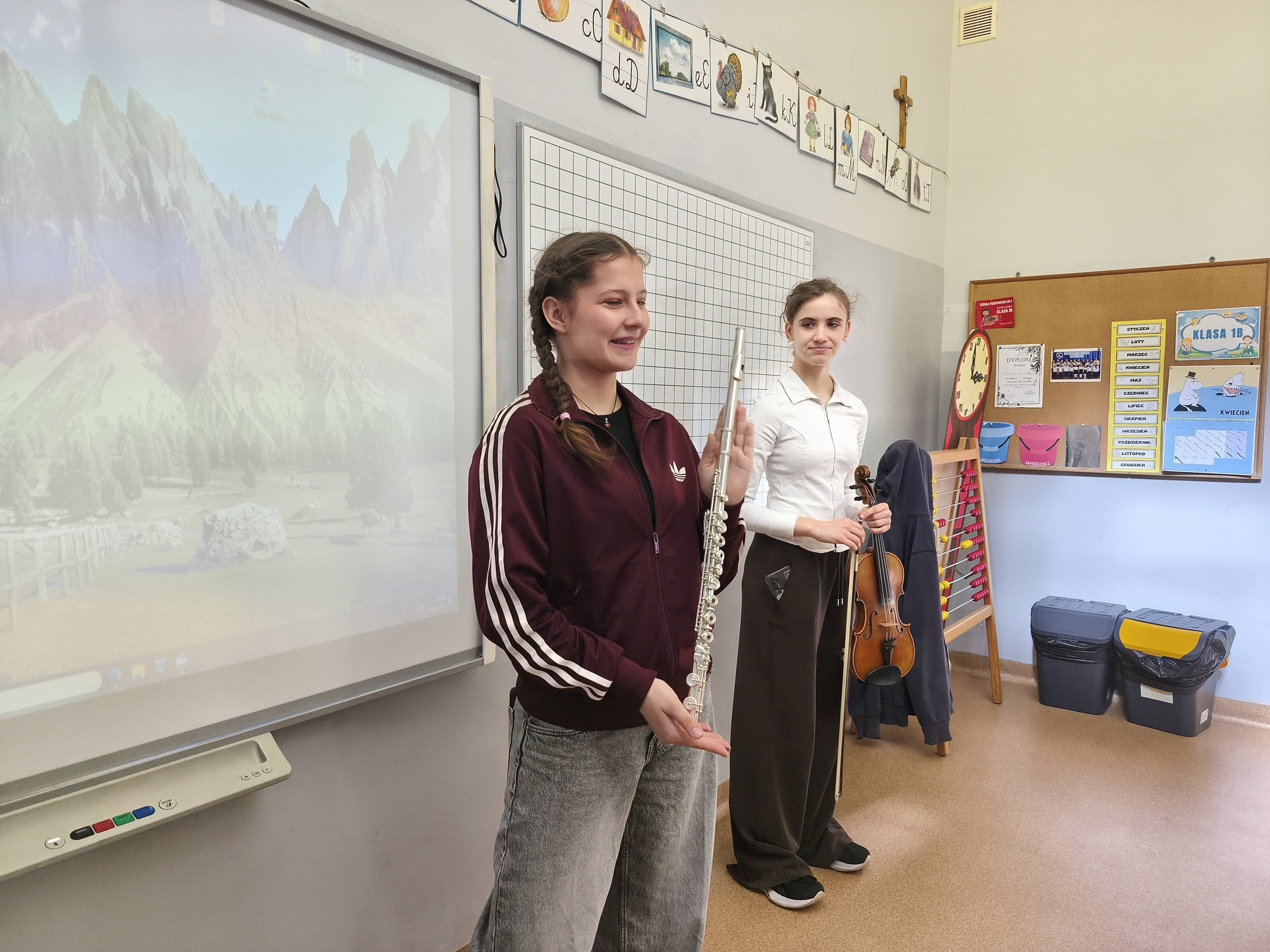 Dziewczynki pokazują instrumenty muzyczne.